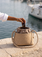 The Antibes in Almond on a harbour ledge, sunglasses dropped into the pouch