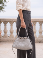 The Antibes in Dove hanging from its braided strap, low side view