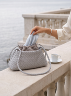 The Antibes in Dove on a terrace balustrade, a silk scarf drawn from the pouch