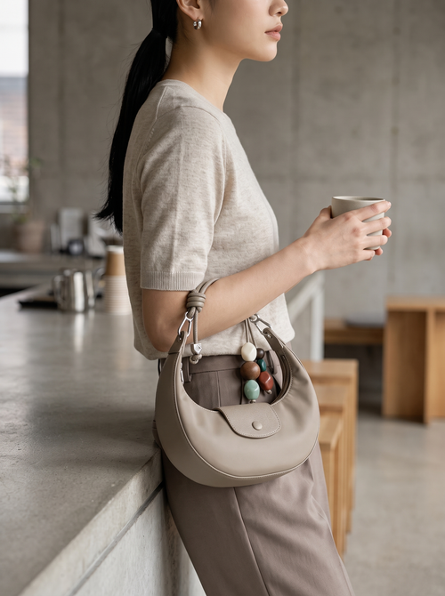 The Demilune in Taupe, carried by hand in a Seoul gallery corridor
