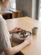The Demilune in Taupe, set down on a cafe table