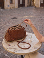 The Antibes in Cognac on a cafe table, drawstring loosened, eight second film