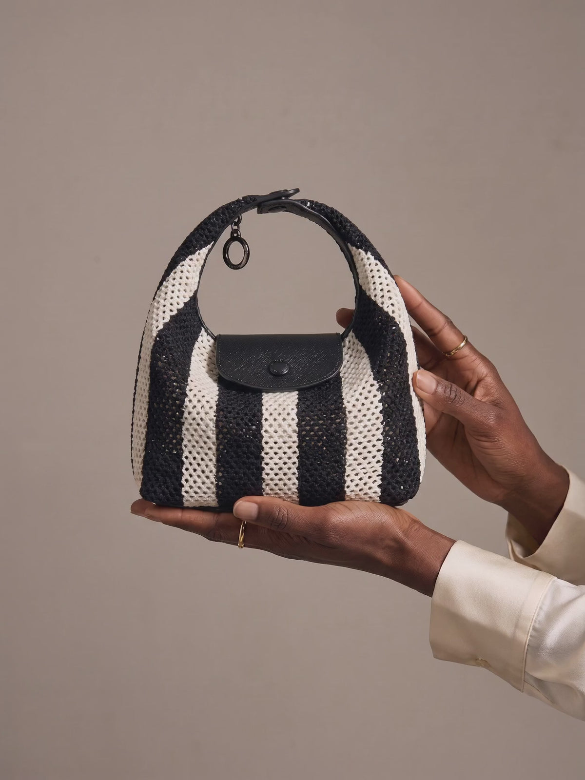 The Deauville in Stripe Noir, turned and presented in the hands